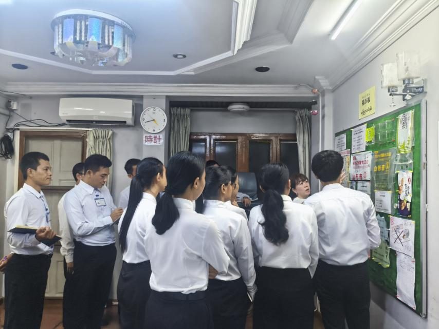 掲示板を囲んで説明を聞く生徒たち